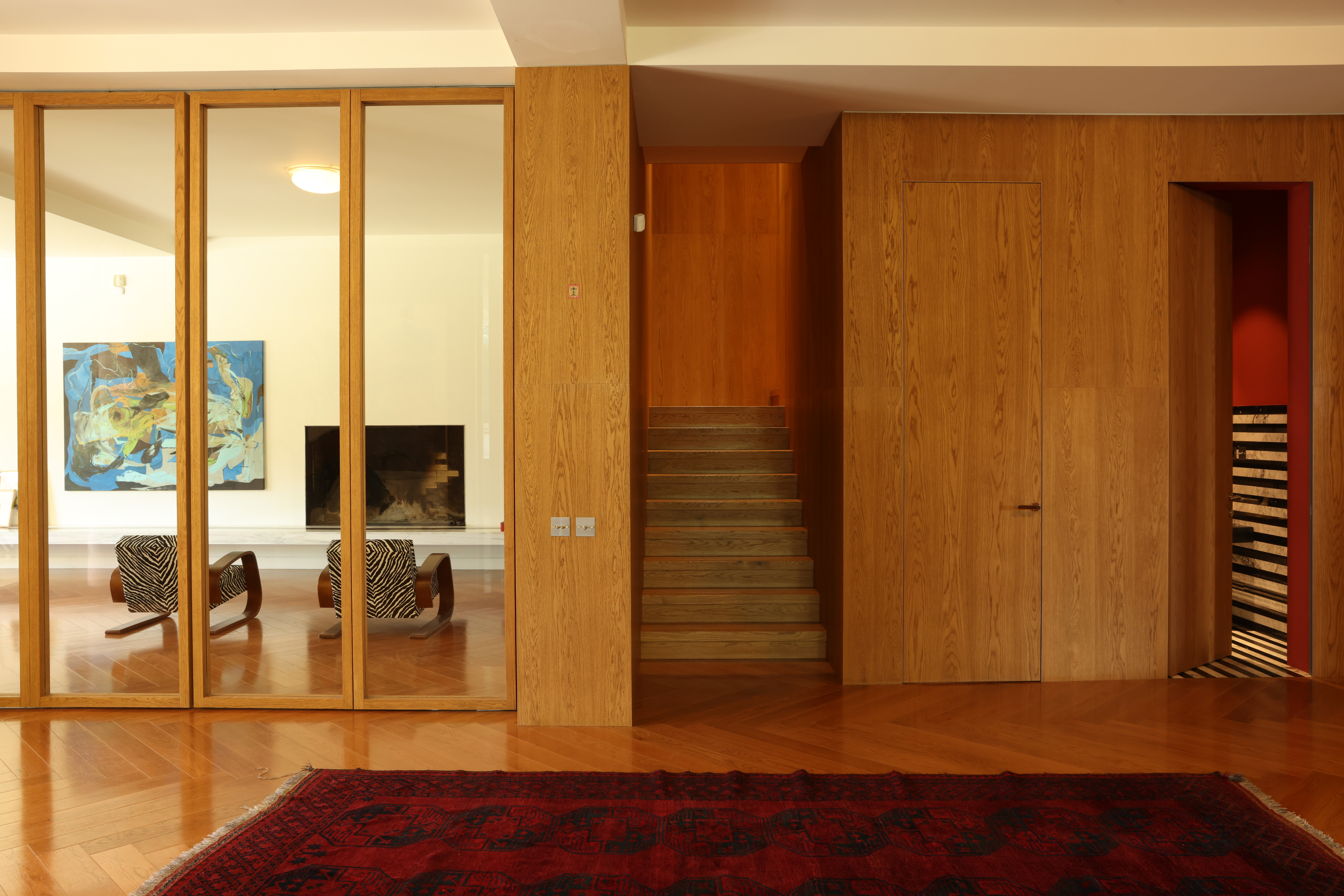 Warm wood interior with partitioned glass and staircase