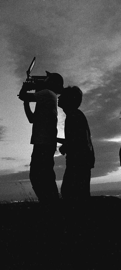 Crew member with a smoke machine creating atmosphere on an outdoor shoot
